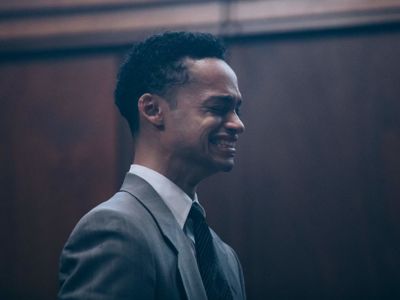 A suited young man cries in a courtroom