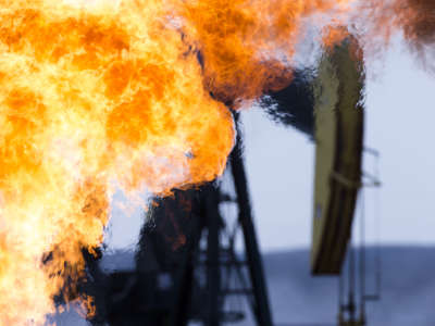 A pumpjack with fire in the foreground