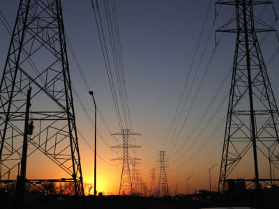 Electrical towers stand aganst the setting sun