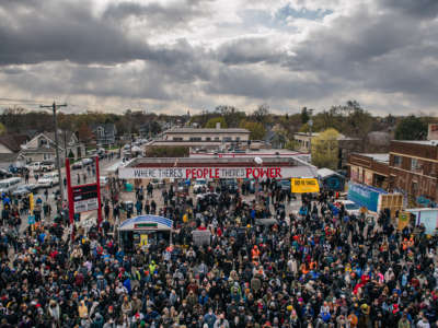 A huge crowd is gathered at the a reclaimed gas station during a rally