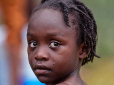A little girl cries while looking into the camera