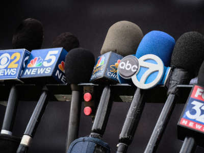 A detailed view of news channel microphones are seen lined up together to record a press conference