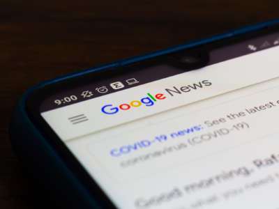a phone is seen displaying the Google search results for covid-19