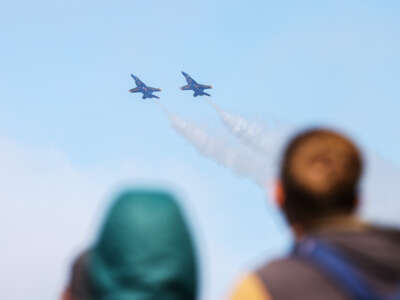 People watch as army jets fly overhead