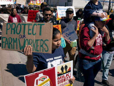 Farmworkers march to a Hannaford supermarket to protest the supermarket chain's refusal to purchase milk from dairy suppliers who have committed to a set of fair labor practices, on May 1, 2022, in Burlington, Vermont.
