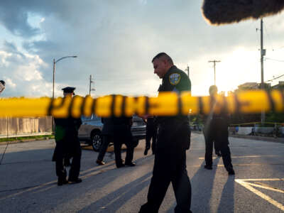 Cops mill around behind police tape