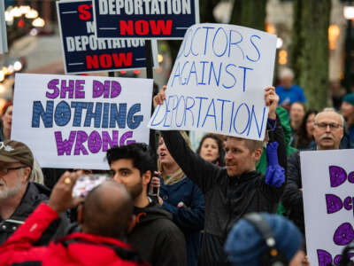 Demonstrators hold signs as they protest the deportation of Assistant Professor of Medicine Dr. Rasha Alawieh of Brown University at the State House in Providence, Rhode Island, on March 17, 2025.