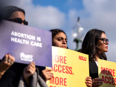 Reproductive rights supporters hold signs and listen to speakers during a news conference on the grounds of the U.S. Capitol on September 12, 2024, in Washington, D.C.