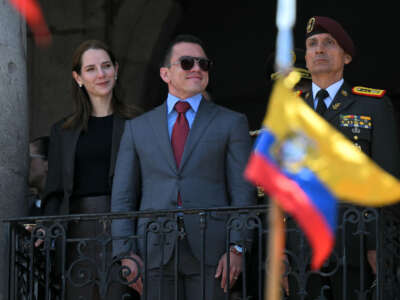Ecuador's President reelect Daniel Noboa (center), accompanied by his wife, Lavinia Valbonesi (left) and the chief of the Presidential Military House, Milton Rodriguez, watches from a balcony of the Carondelet Presidential Palace the changing of the guard ceremony in Quito on April 15, 2025.