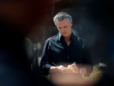 California Gov. Gavin Newsom takes notes during a news conference at Gemperle Orchard on April 16, 2025, in Ceres, California.