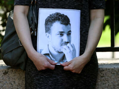 A protester holds an image of Mahmoud Khalil, a graduate student at Columbia who played a significant role in the student protests against Israel's war on Gaza before being picked up by ICE as she stood with others at a press conference at Harvard University in Cambridge, Massachusetts, May 12, 2025.