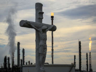 A cross in a cemetery stands near a petrochemical manufacturing plant on August 21, 2019, in Hahnville, Louisiana.