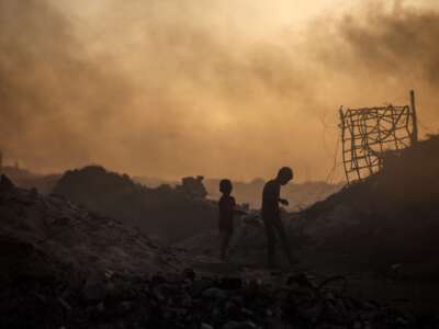 Displaced Palestinian children search for plastic to use for cooking near Gaza's port in Gaza, Palestine, on November 13, 2025.