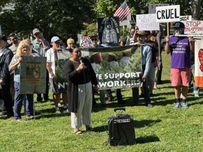 Ana Mendez of Rural & Migrant Ministry speaks at a press conference and rally in front of a sign that says "Support Workers" on September 19 in Fulton, New York.