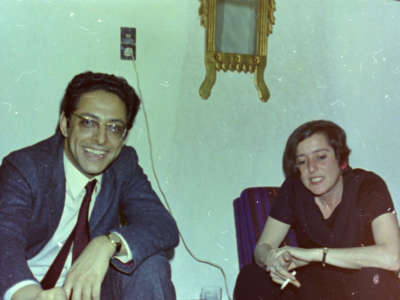 A man and a woman sit next to eachother in two different chairs