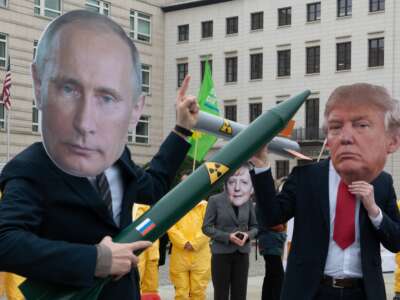 Demonstrators wearing masks of Vladimir Putin, Donald Trump, and Angela Merkel face each other with rocket models, protesting against the imminent end of a disarmament agreement between Russia and the U.S., on February 1, 2019, in Berlin, Germany.