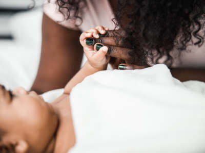 Close-up of baby hand holding mommy's fingers.