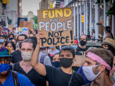 A participant holding a Defund Police sign at the protest.