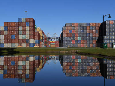 Shipping containers are seen reflected in a pond at the Port of Savannah in Georgia on October 23, 2021. The supply chain crisis has created a backlog of nearly 80,000 shipping containers at this port, the third-largest container port in the United States.