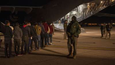 U.S. Customs and Border Protection Agents watch immigrants board a deportation flight at the Tucson International Airport, in Tucson, Arizona, on January 23, 2025.