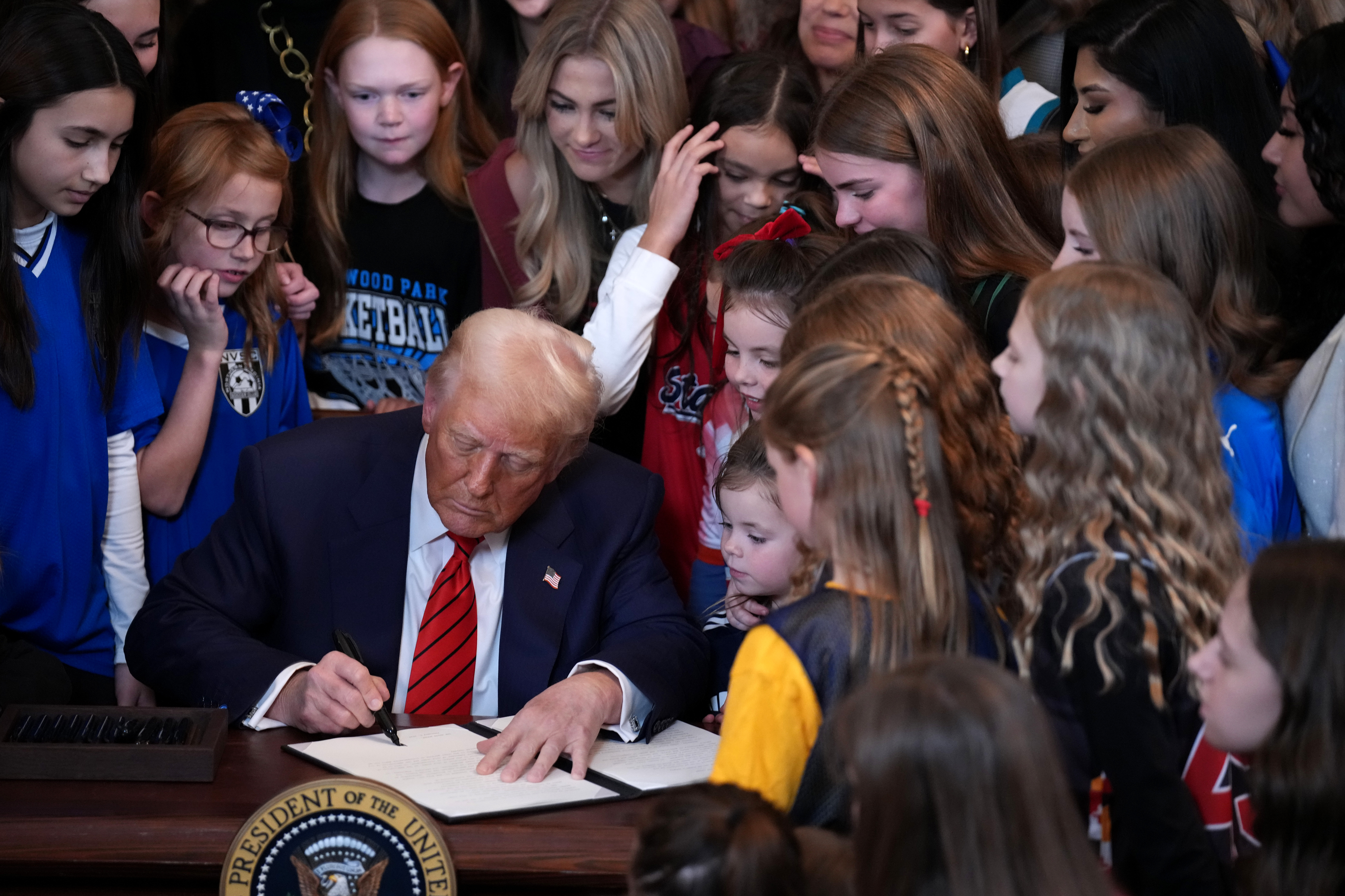 U.S. President Donald Trump joined by women athletes signs an executive order discriminating against transgender athletes in the East Room at the White House on February 5, 2025 in Washington, D.C.
