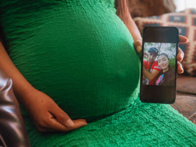 A pregnant woman in Dallas, Texas, shows a photograph of herself and her partner, who was recently detained by U.S. Immigration and Customs Enforcement (ICE) during a check-in, on March 20, 2025.