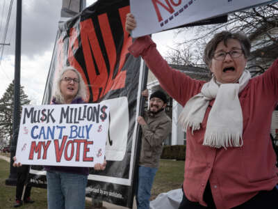 Demonstrators protest outside of an event hosted by Circuit Court Judge Brad Schimel, candidate for the Wisconsin Supreme Court, on March 25, 2025, in Jefferson, Wisconsin. Schimel, who has been endorsed by President Trump and financially supported by billionaire businessman Elon Musk, is running against Dane County Circuit Court Judge Susan Crawford.