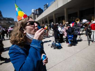 People at Nathan Phillips Square in Toronto, Ontario, protest on April 17, 2025, against a controversial "bubble zone" bylaw restricting protests in Toronto to certain areas. The rally also commemorated the 43rd anniversary of the Canadian Charter of Rights and Freedoms.