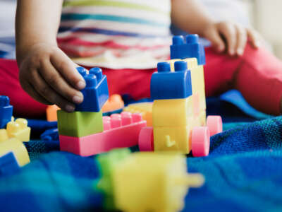 Toddler plays with brick toys inside