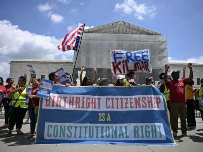People hold a banner as they protest outside the Supreme Court over Donald Trump’s move to end birthright citizenship, on May 15, 2025.