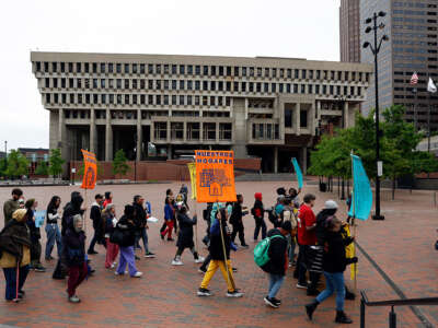 people in coats marching with signs