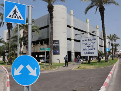 People walk past a sign directing to the police station at Ben Gurion Airport
