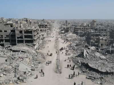 In this aerial view, people walk amid the destruction in Gaza City in the northern Gaza Strip on October 11, 2025, a day after a ceasefire took effect.