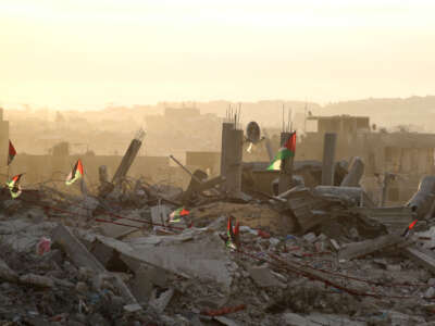 Palestinian flags flutter on top of rubble in Gaza City on October 12, 2025.