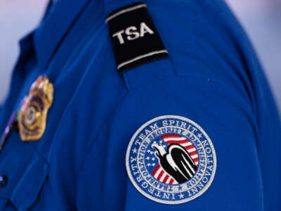 A detailed view of a Transportation Security Administration (TSA) patch on an employee's shirt at Orlando International Airport (MCO) on November 9, 2025, in Orlando, Florida.
