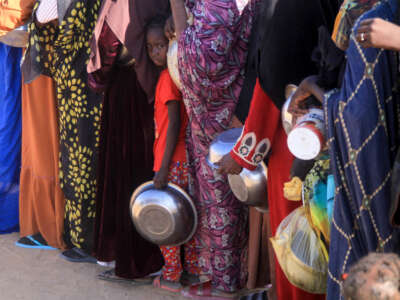 A Sudanese girl who fled El-Fasher lines up with other women to receive a free meal at the Al-Afad camp for displaced people in the town of Al-Dabba, Sudan, on November 20, 2025.