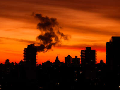 An emission comes out of a smoke stack as the sun rises in New York City on December 28, 2025, as seen from Jersey City, New Jersey.