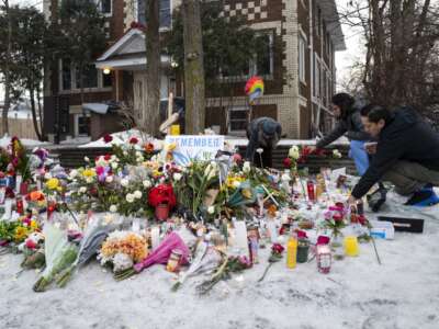 People tend to a memorial for Renee Nicole Good near the site of her shooting, on January 8, 2026, in Minneapolis, Minnesota.