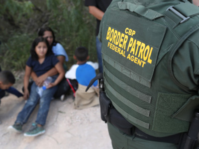 Central American asylum seekers wait as US Border Patrol agents take them into custody on June 12, 2018 near McAllen, Texas. The families were then sent to a US Customs and Border Protection processing center for possible separation.
