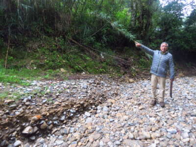 Jaime Betanzos demonstrates the damage caused to his community's river by dredgers mining for gravel and sand.