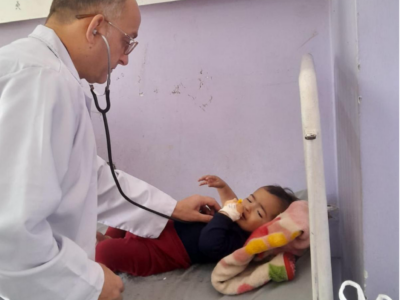 Ghada Eyad’s father, a pediatrician at Al-Aqsa Hospital in Gaza, examines a 19-month-old infant suffering from respiratory distress.